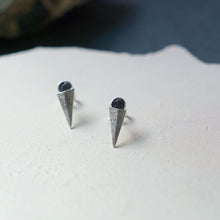 Load image into Gallery viewer, A pair of silver stud earrings with ear sticks. Uncut raw rough black diamonds nested on top of a folded blade of silver. Sold as a pair or singularly, perfect for layering with studs or drops for an asymmetric look. They feature an organic texture and are made of recycled silver which has been hand-scored, folded and oxidised to accentuate the texture. Handmade in Copenhagen by Scottish designer Caroline Cloughley.