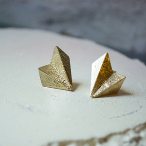 A pair of unusual fan shaped earrings. The silver is folded  like origami paper and has a rough rustic texture. They are made in recyceld sterling silver and plated with 24ct gold. Made in Copenhagen by Scottish designer Caroline Cloughley.