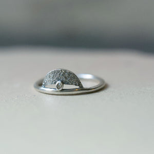 A beautiful and unusual champagne diamond ring. Made in recycled sterling silver with an organic texture. The diamond sits on top of the silver band with a crescent moon shape above it.